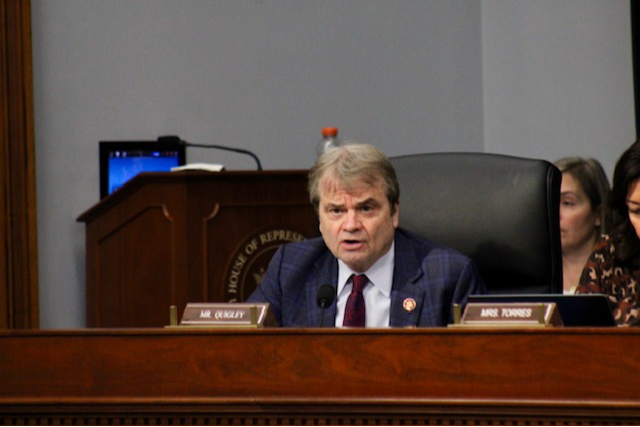 Rep Quigley speaks from a dais animatedly