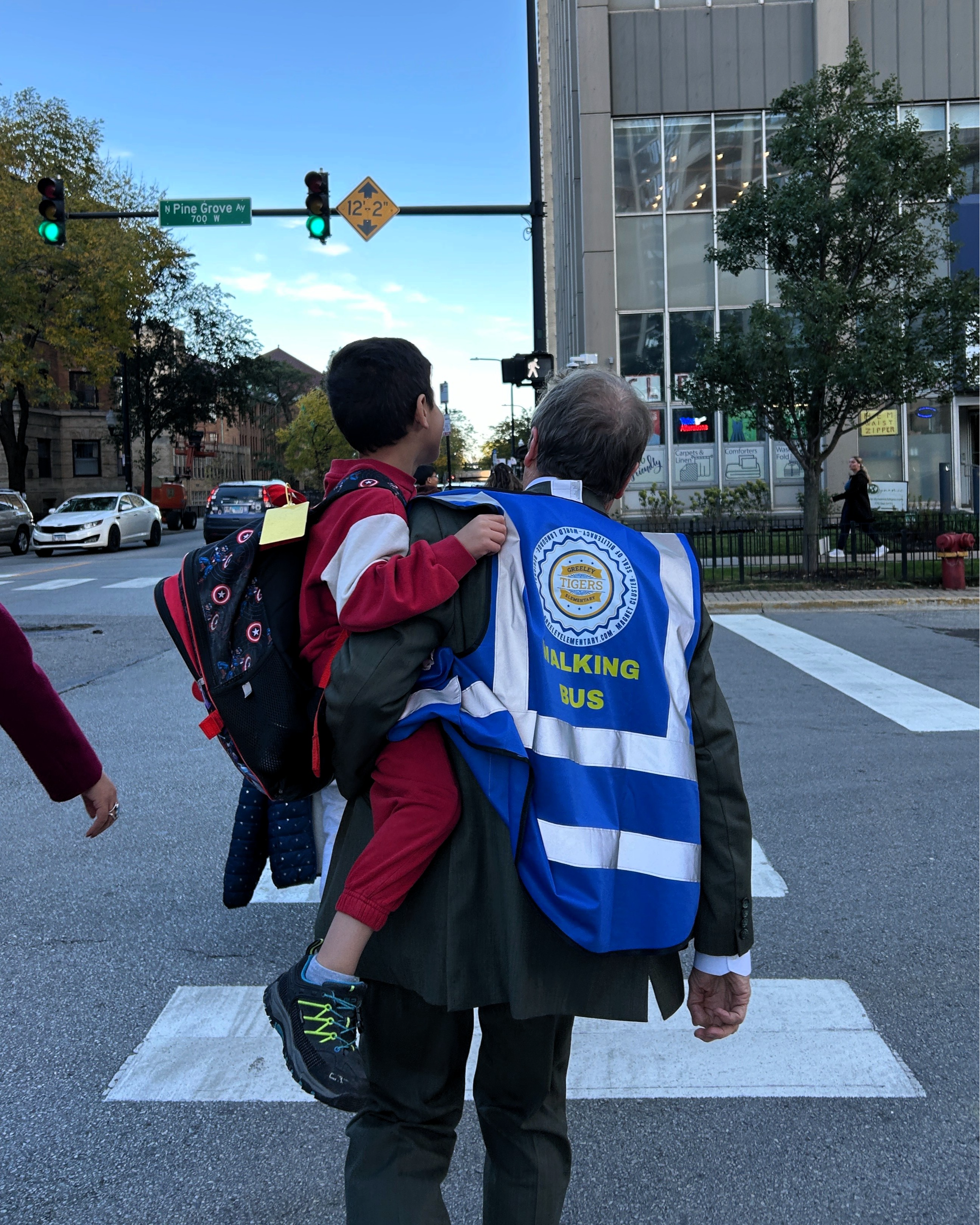 Rep. Mike Quigley carries a child while wearing a blue 