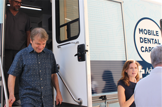 Quigley exits a van that has been retrofitted as a mobile dental car center